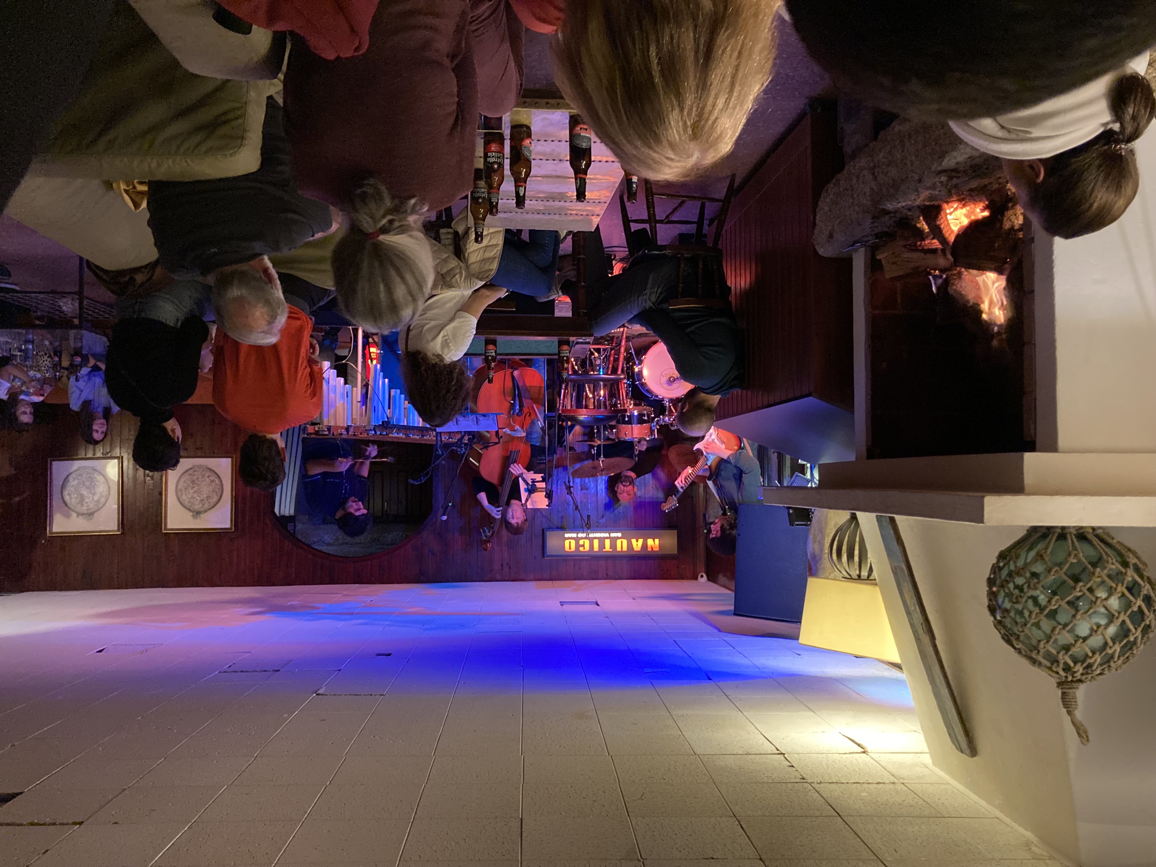 a band playing in a crowded pub, fire place on the left side