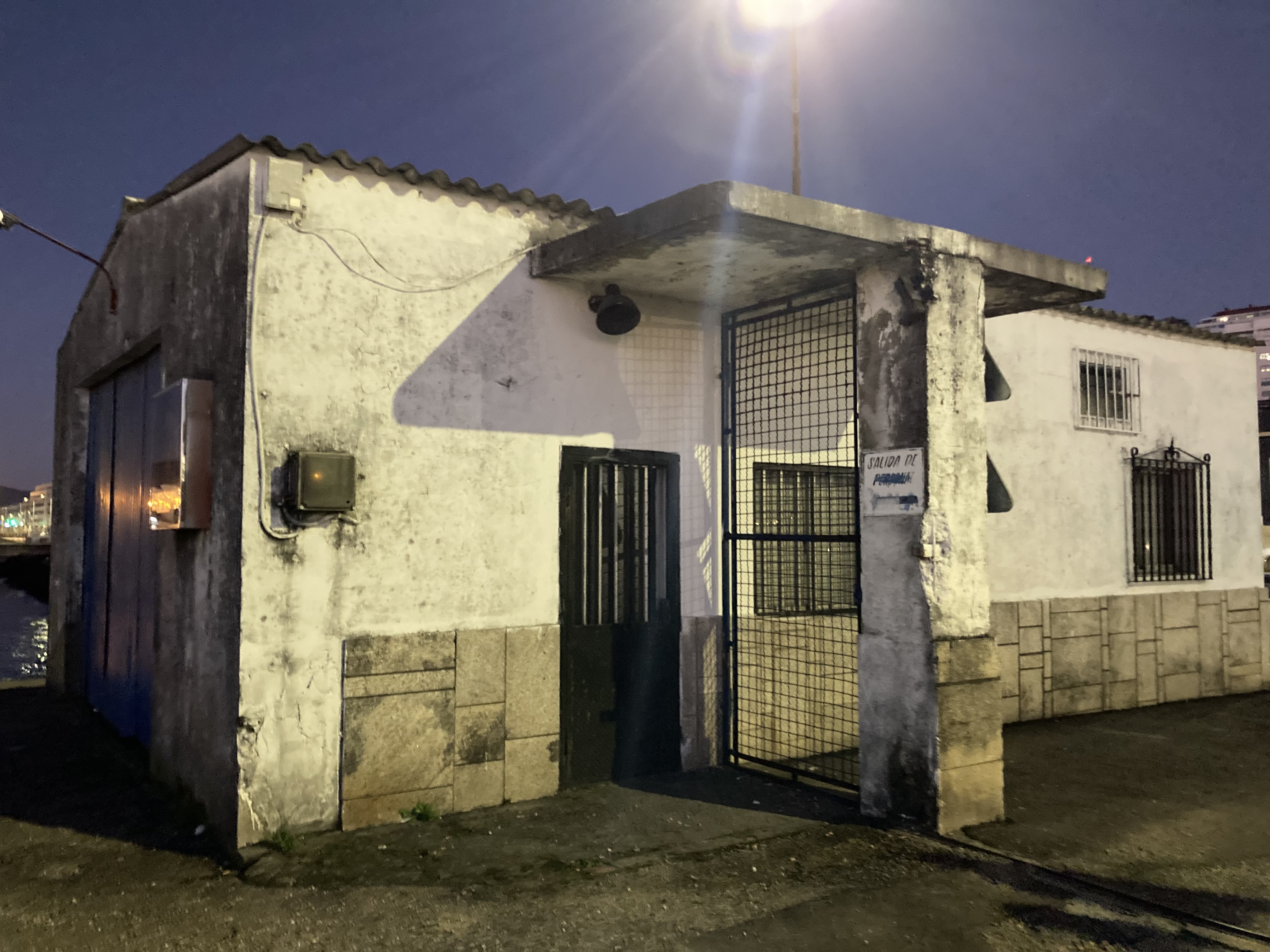 an old security entrance building to the port, greyly rusting in the night